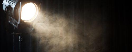 vintage theatre spot light on black curtain with smoke vintage theatre spot light on black curtain with smoke